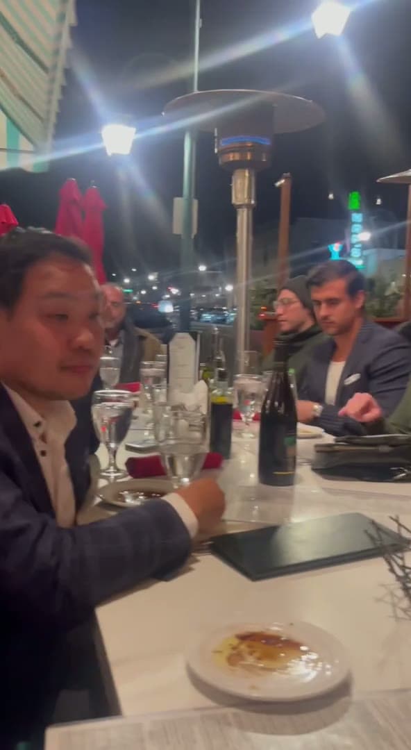 Ty and friends at an evening dinner on a city patio