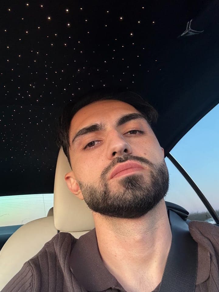 Selfie from the passenger seat under a starlight headliner, in a ribbed brown polo